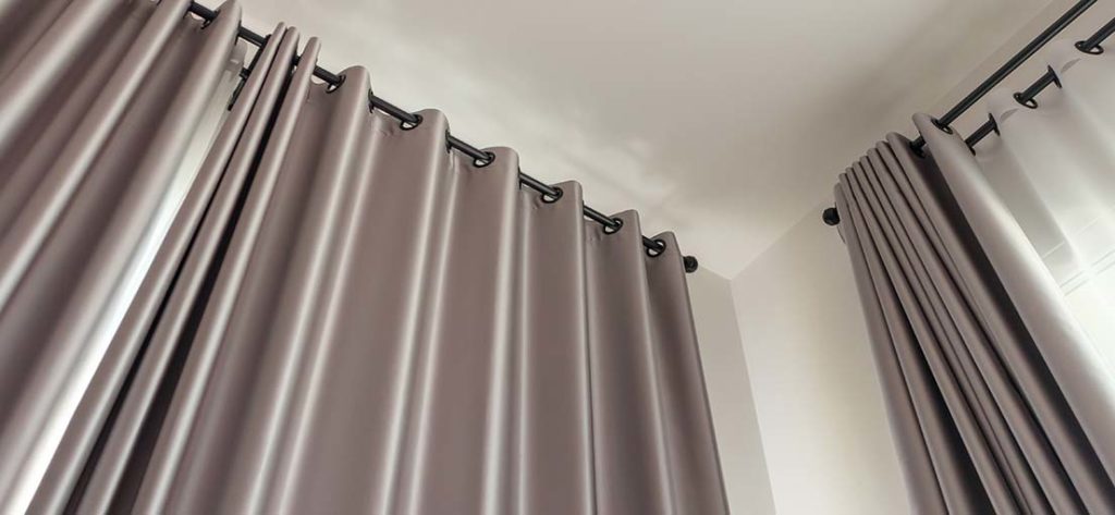 Light-blocking grey blackout curtains create a dark and calming bedroom environment.