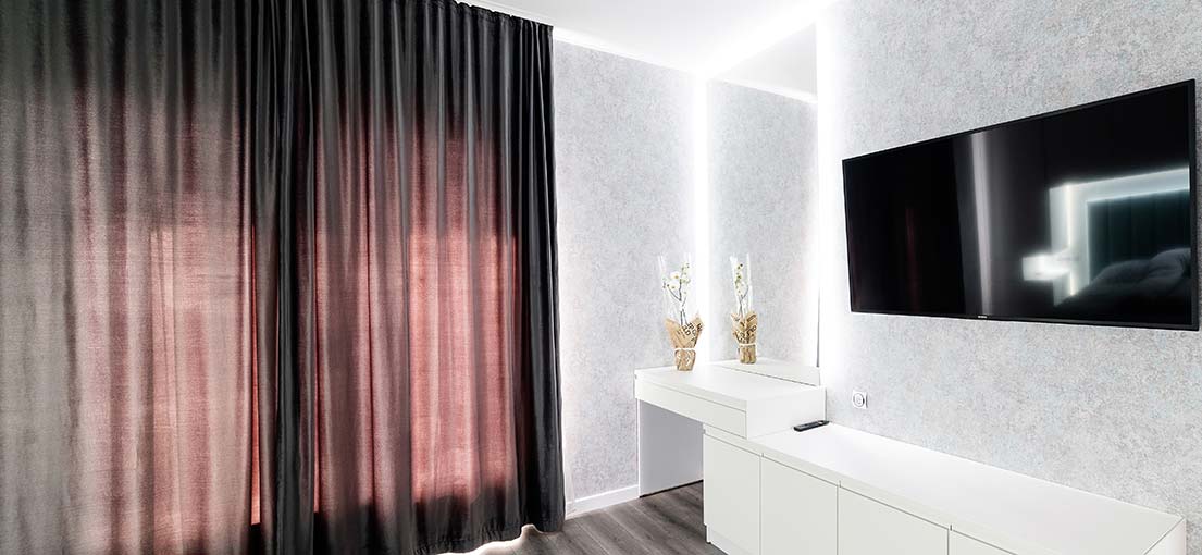 Sleek grey blackout curtains with a smooth finish, reaching the floor for a polished look.