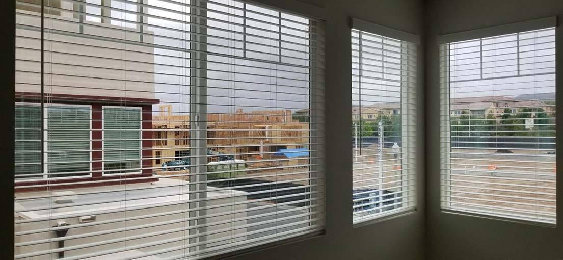 Venetian blinds frame the sunny California coast in a Long Beach office.