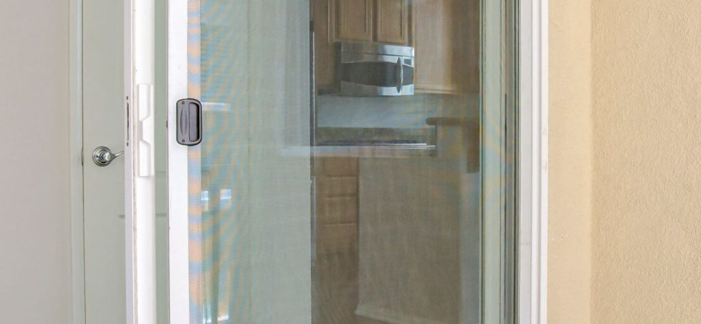 Bandini home's sliding glass door featuring vertical blinds in a neutral tone