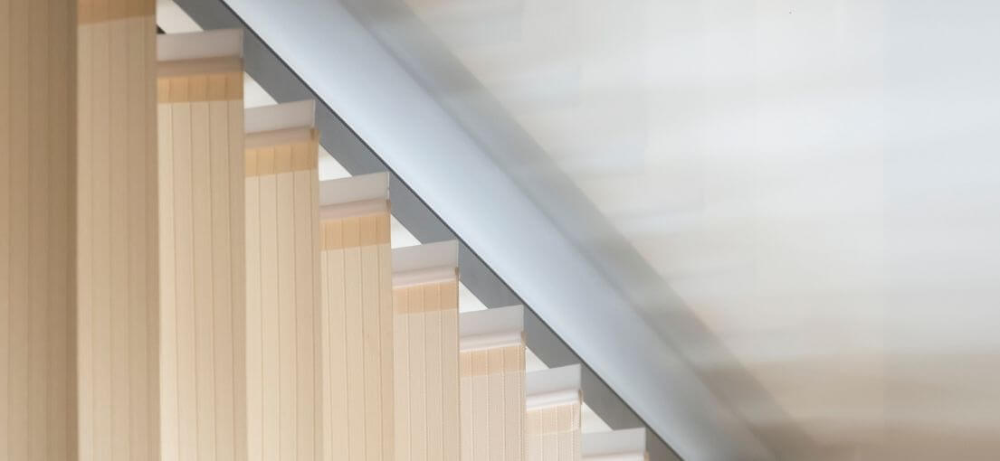 A close-up of sleek vertical blinds covering a sliding glass door, offering privacy and light control
