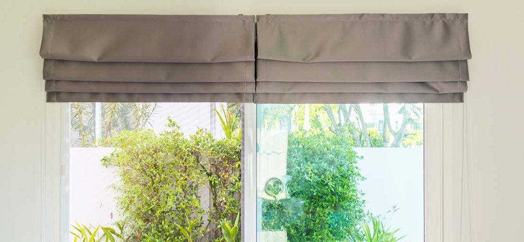 Light filtering grey Roman shades offer privacy and gentle light control.