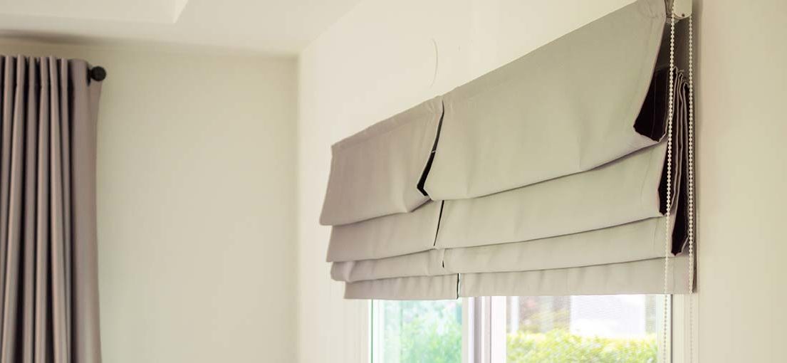 Modern grey Roman shades provide a clean look for a window.