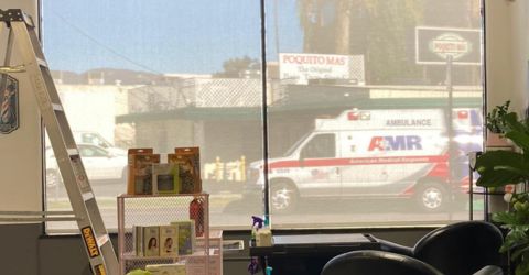 A view through the hair cut salon window covered with sheer roller shades