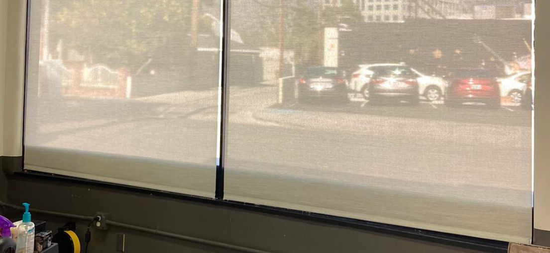 A view through the hair cut salon window covered with sheer roller shades