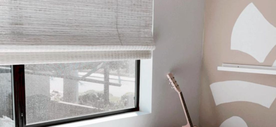 A view to a window covered with woven wood shades