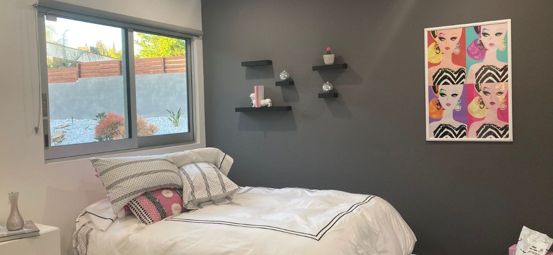 Girls bedroom space with custom roller shades from Master Blinds.