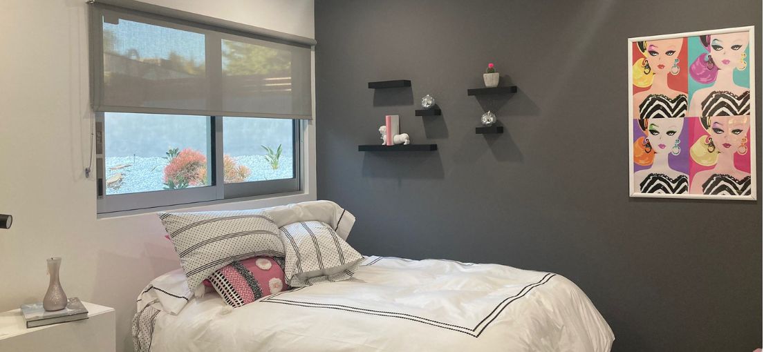 Girls bedroom space with custom roller shades from Master Blinds.