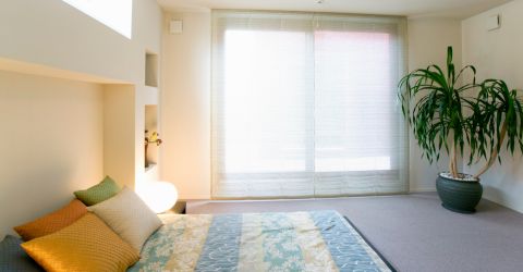 Bright bedroom adorned with sheer light Roman shades on elegant balcony glass doors by Master Blinds in Marina Del Rey