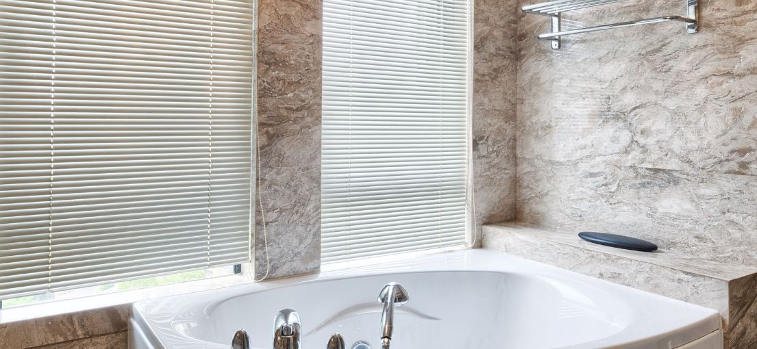 Chic window treatment with mini blinds in a lavish bathroom