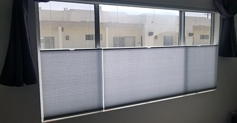 A bedroom window wall with cellular shades