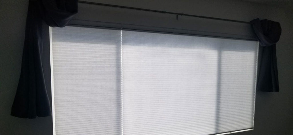 A close up view to a window covered with cellular shades
