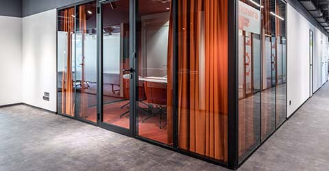 Glass office walls covered with orange curtains