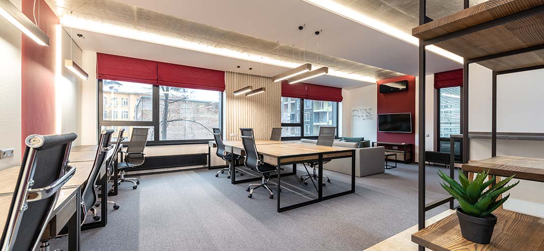 A look at modern office with dark red Roman shades on windows