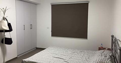 White bedroom with dark grey blackout blinds