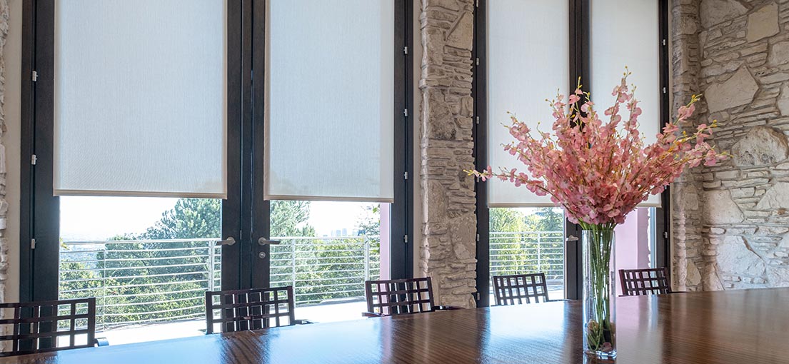 A close up to the tall dinning room windows with custom made motorized shades