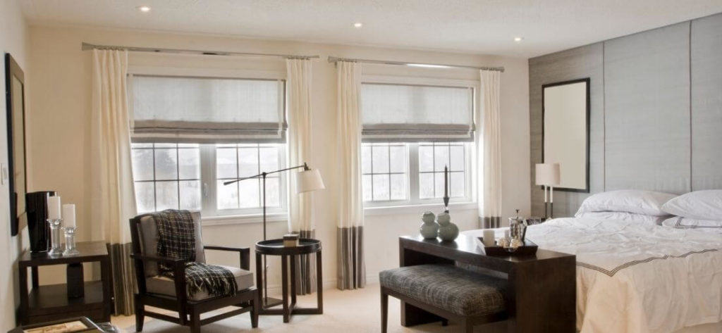 A view at motorized Roman shades in bedroom