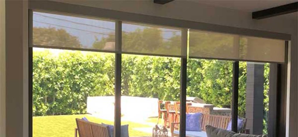 Close-up of a motorized white window shade cassette, installed in a Reseda home.