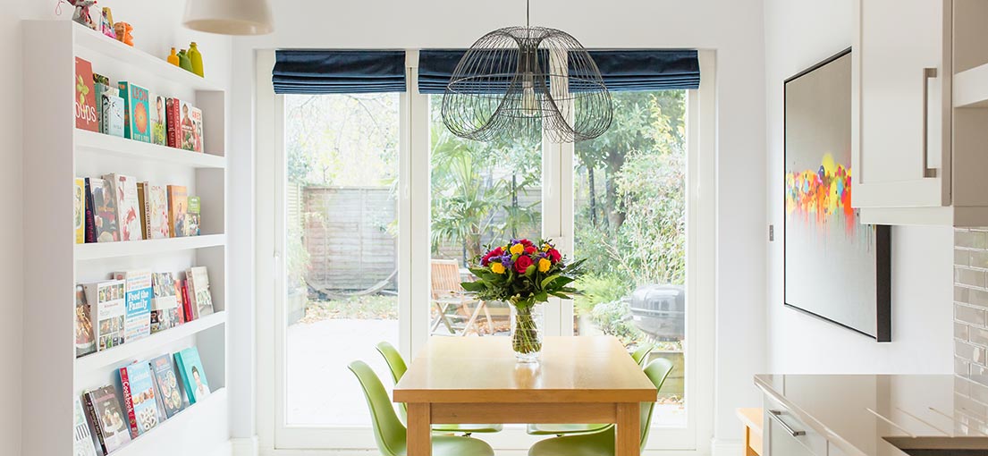 A lovely bright dinning room with dark blue Roman shades