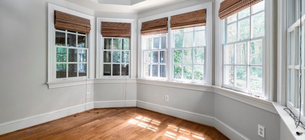 Bay area windows covered with brown Roman shades