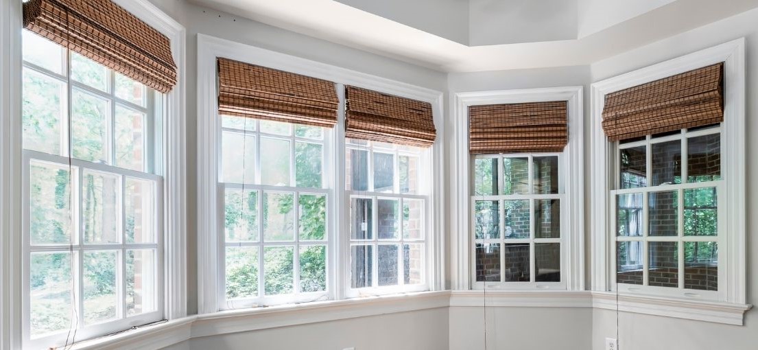 A view to bay windows covered with Roman shades