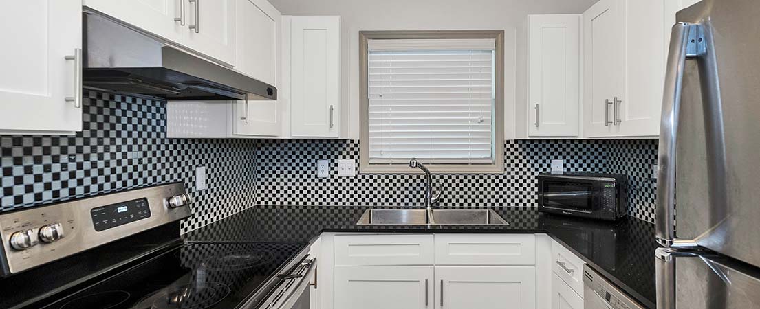 Kitchen window covered with simple white Venetian blinds