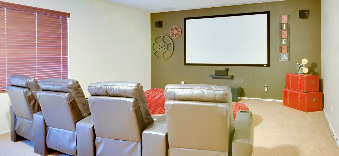 A view to a home theater with red aluminum window binds