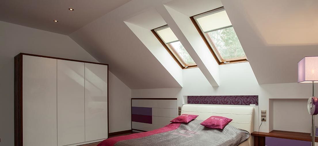 A view on two skylight windows with shades in a bedroom