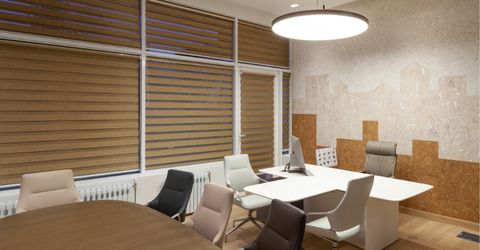 An office room interior with layered window shades