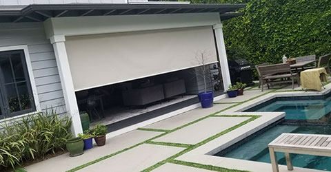 Exterior shades facing backyard with a pool
