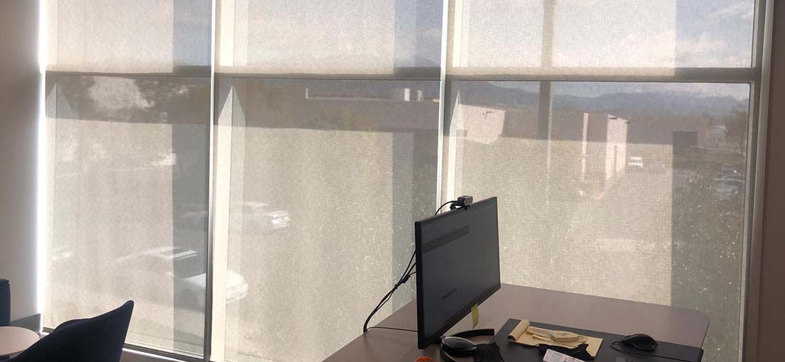 A view at motorized roller shades in commercial office