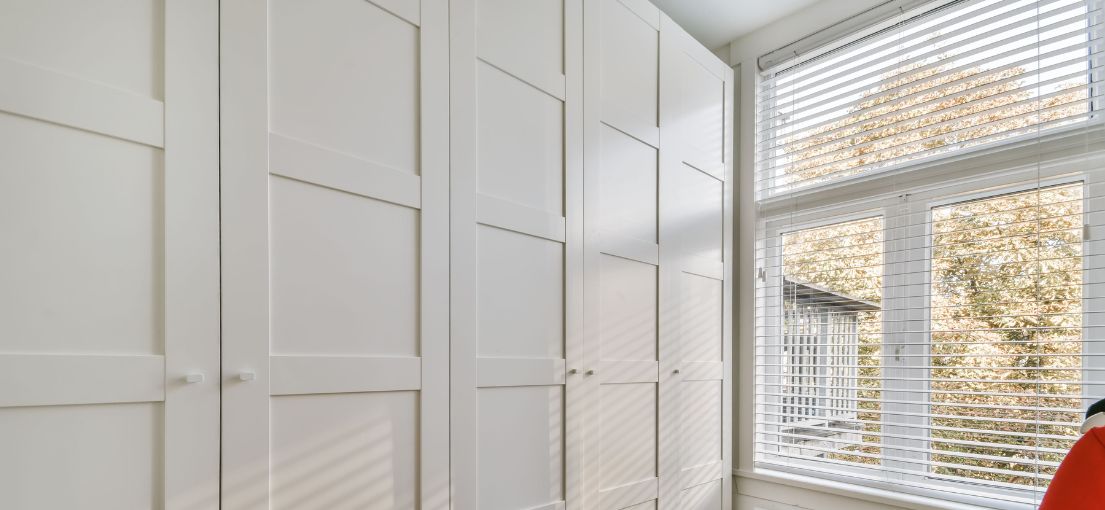 A view into closet room with aluminum blinds