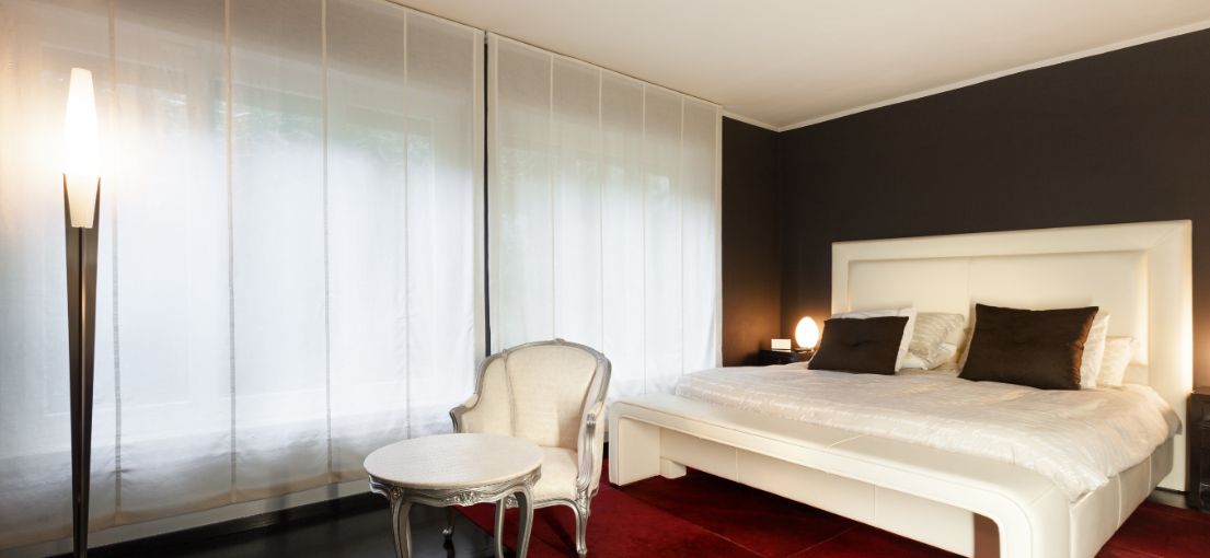 Luxury bedroom with silky Roman window shades