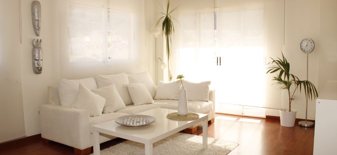 Castaic living room featuring electric window shades and a white sofa.