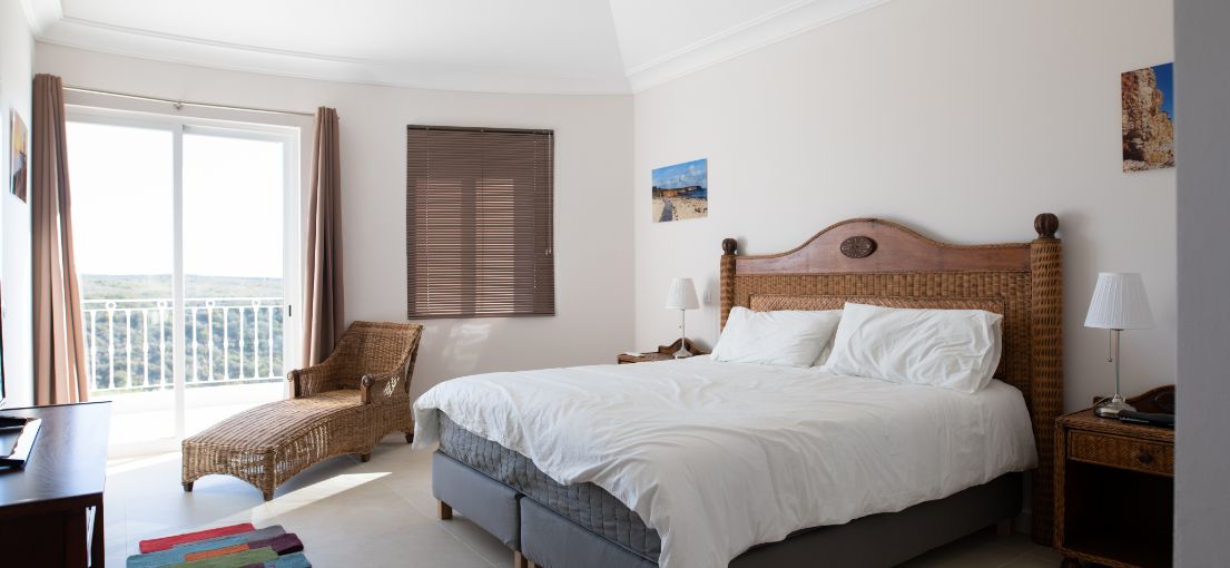 In this bedroom, rich brown Venetian blinds offer a timeless and stylish window treatment, blending seamlessly with the room's decor for a harmonious look and feel.
