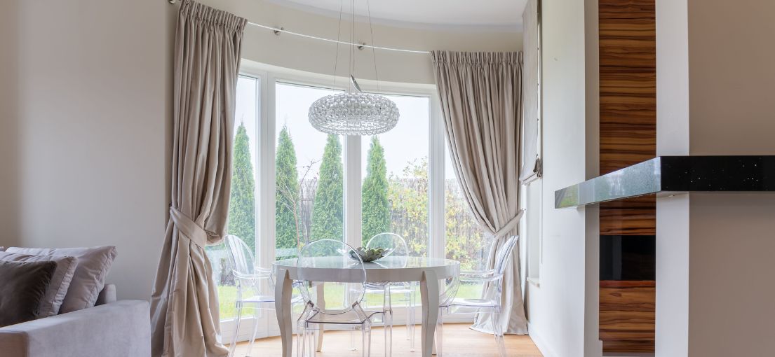 Sunland dining area adorned with Master Blinds' exquisite Roman shades and beautiful silky curtains.