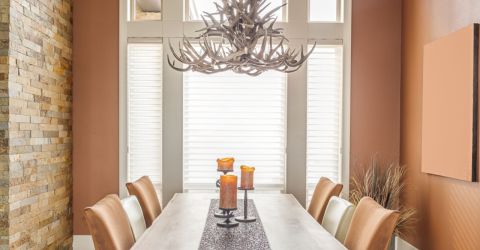 Elegant dining area with faux wooden blinds in West Hollywood home